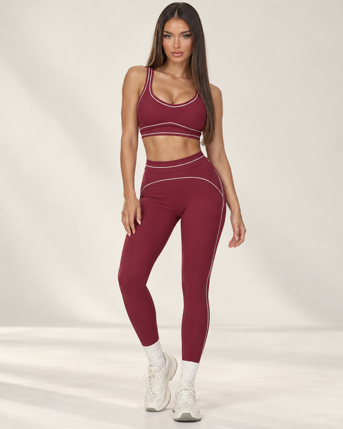 cherry red women’s gym outfit with a fitted sports bra and high waisted flared activewear leggings, detailed with curved contrast seams and white piping for a body contouring workout, training and athleisure look