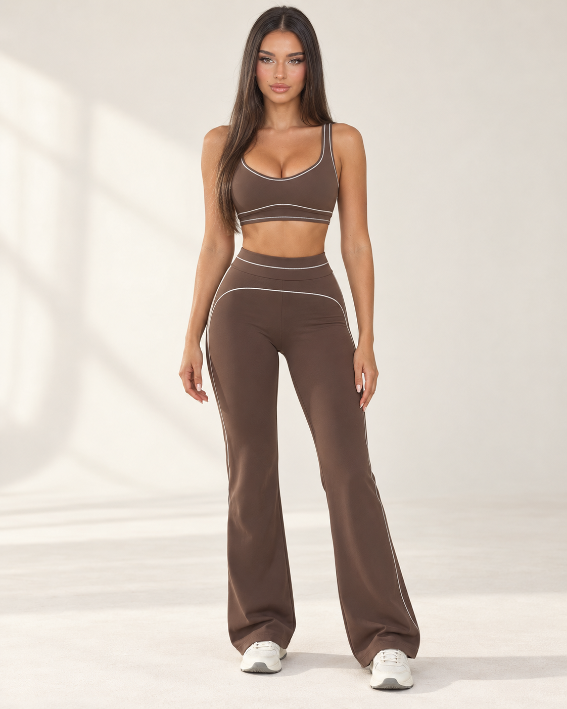 mocha women’s gym outfit with a fitted sports bra and high waisted flared activewear leggings, detailed with curved contrast seams and white piping for a body contouring workout, training and athleisure look