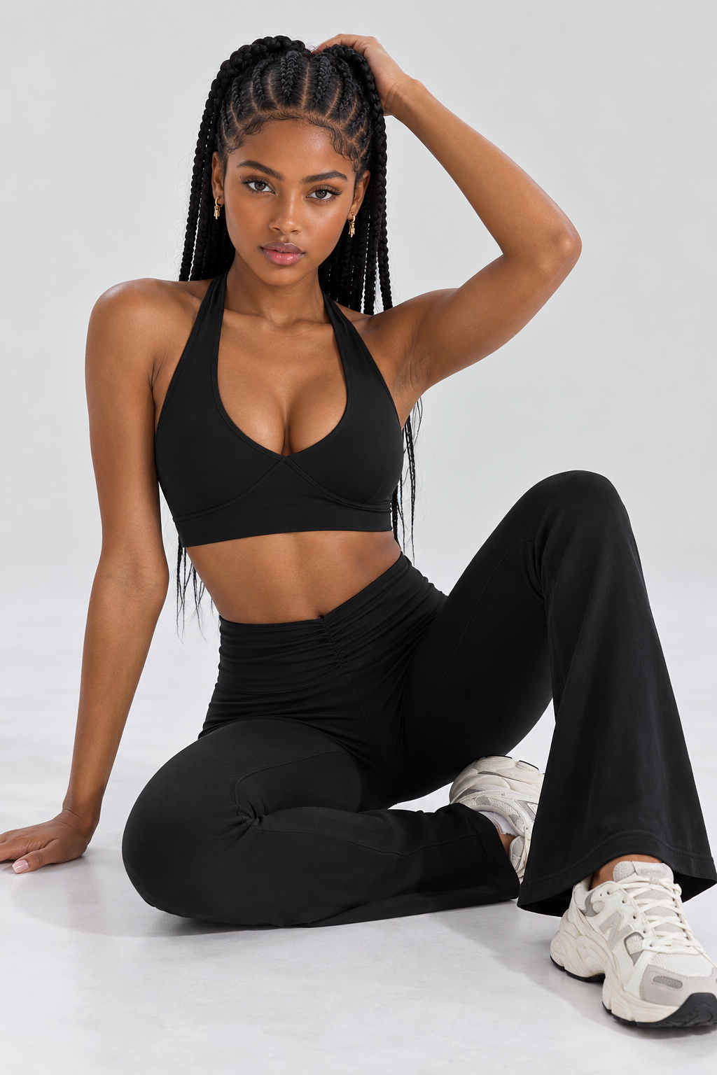 black women's gym outfit combining a supportive halter-style sports bra with contoured bust stitching and matching high-rise flare leggings.