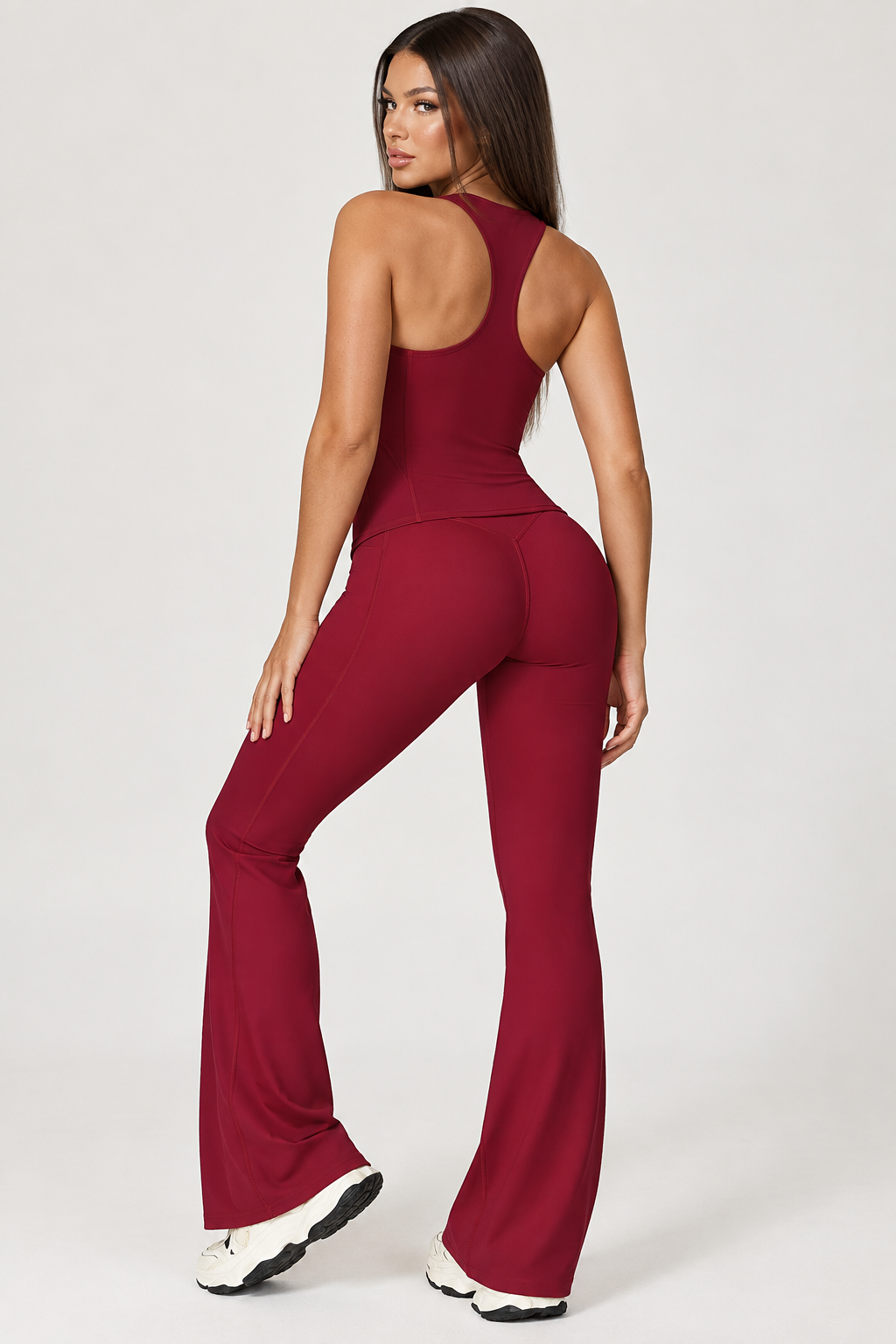 red women’s workout activewear set featuring a body contouring sleeveless crop top and high rise crossover waist leggings, styled as a feminine coordinated gym outfit for exercise and training