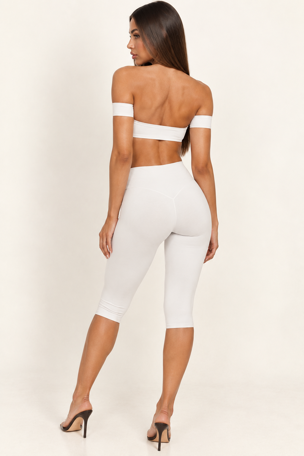 white women's two-piece Pilates set featuring a straight-neck bandeau top, delicate shoulder bands and streamlined ankle-length leggings.