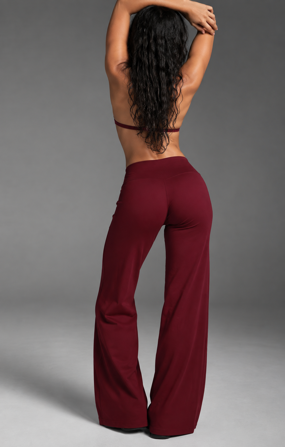 Dark cherry women’s gym set with an elegant strappy back sports bra and flattering high waist flow-leg trousers