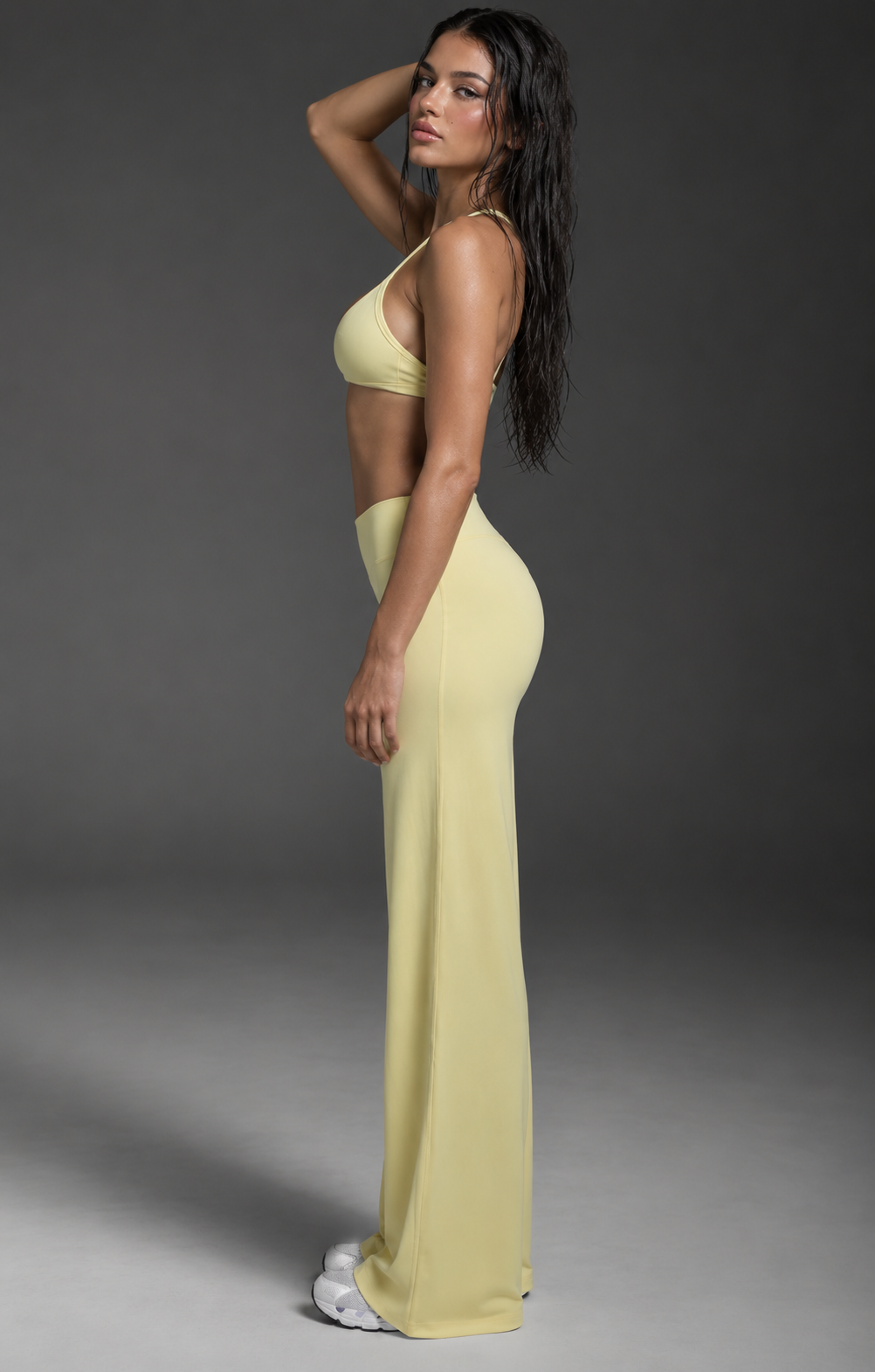 buttercream yellow women’s studio outfit featuring a minimalist V-front sports bra and relaxed wide leg performance pants