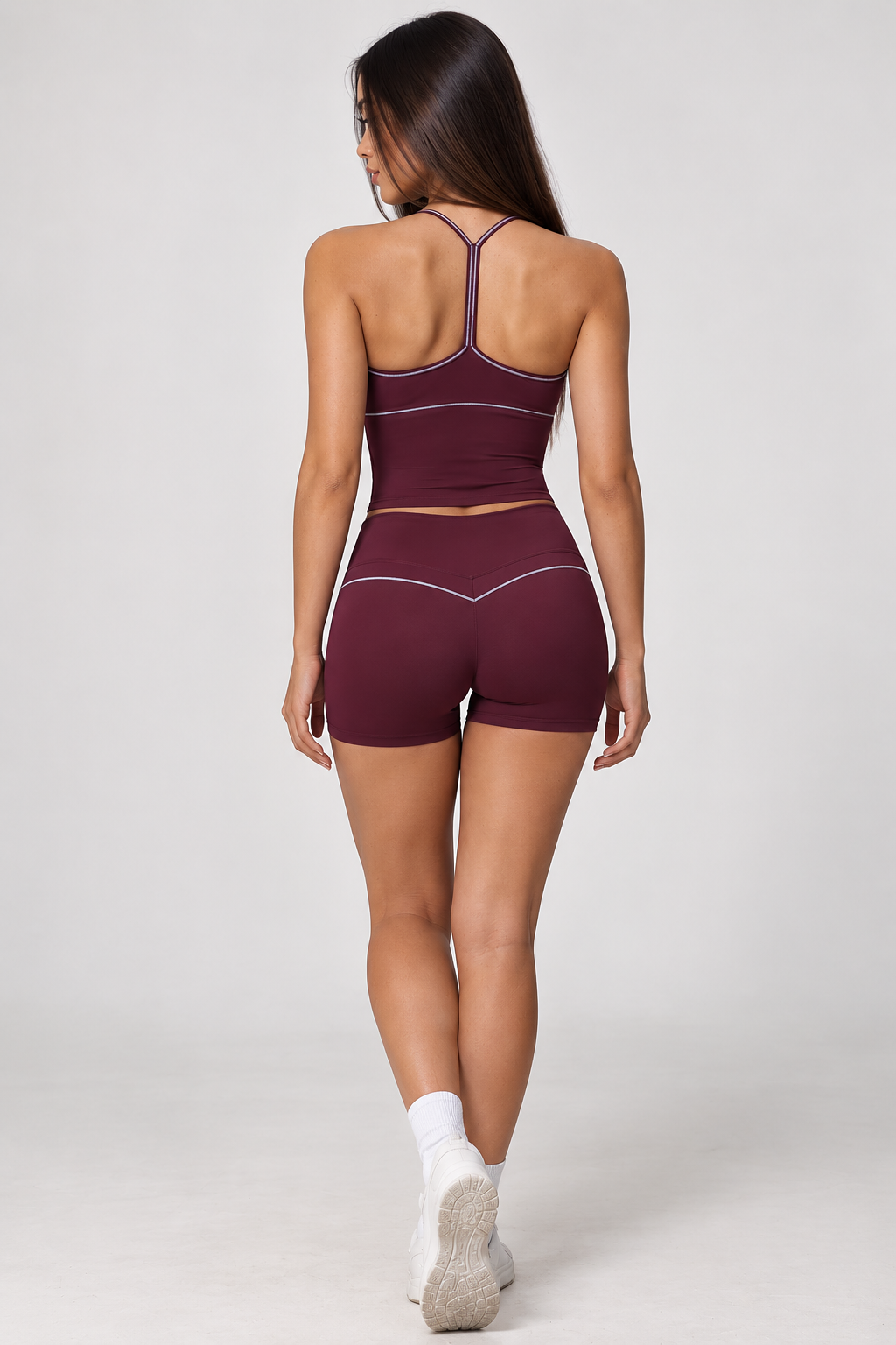 dark red women's gym co-ord featuring a fitted V-neck sports bra, fine spaghetti straps and matching compression-style shorts with subtle waistband detailing.
