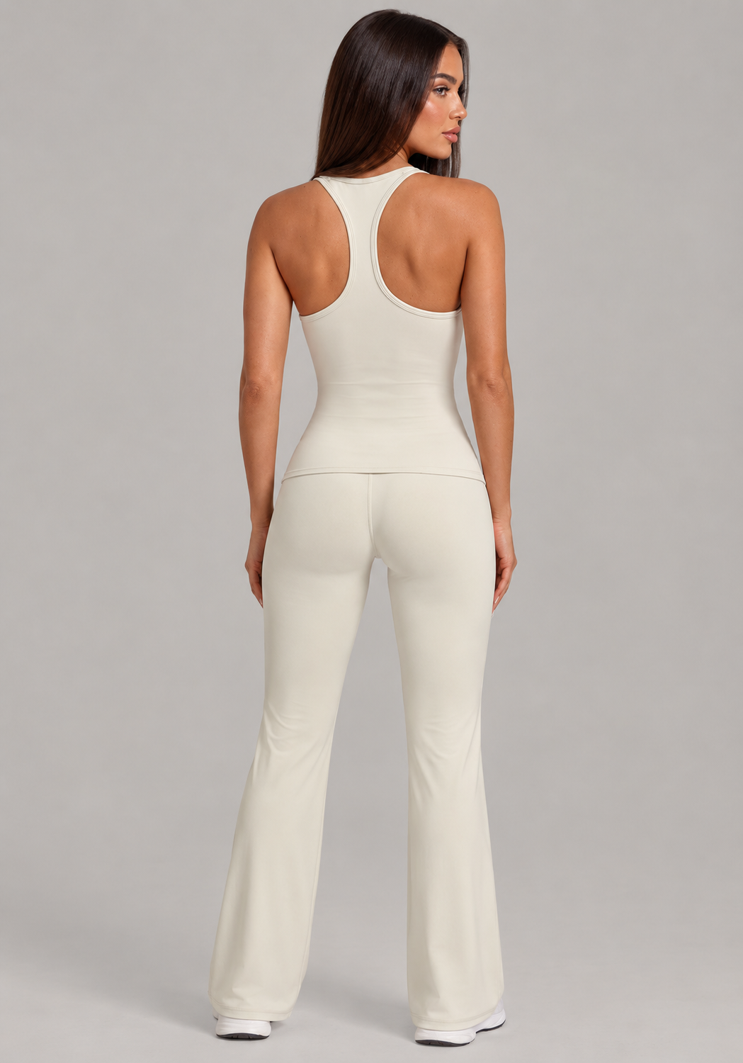 cream women’s activewear set featuring a high neck cropped sports bra and high waisted V front flare leggings