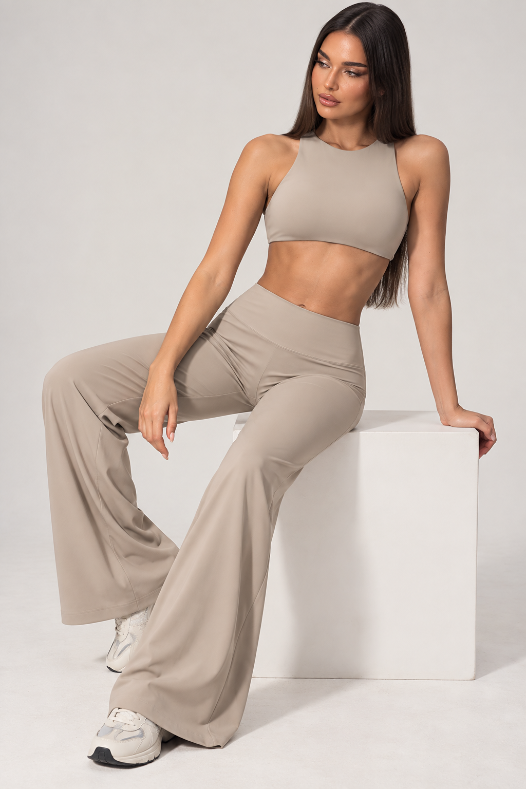 khaki women’s fitness outfit with a sleeveless halter workout top and high rise wide leg gym pants, a matching activewear set with a fitted waist and flowing full length trouser design