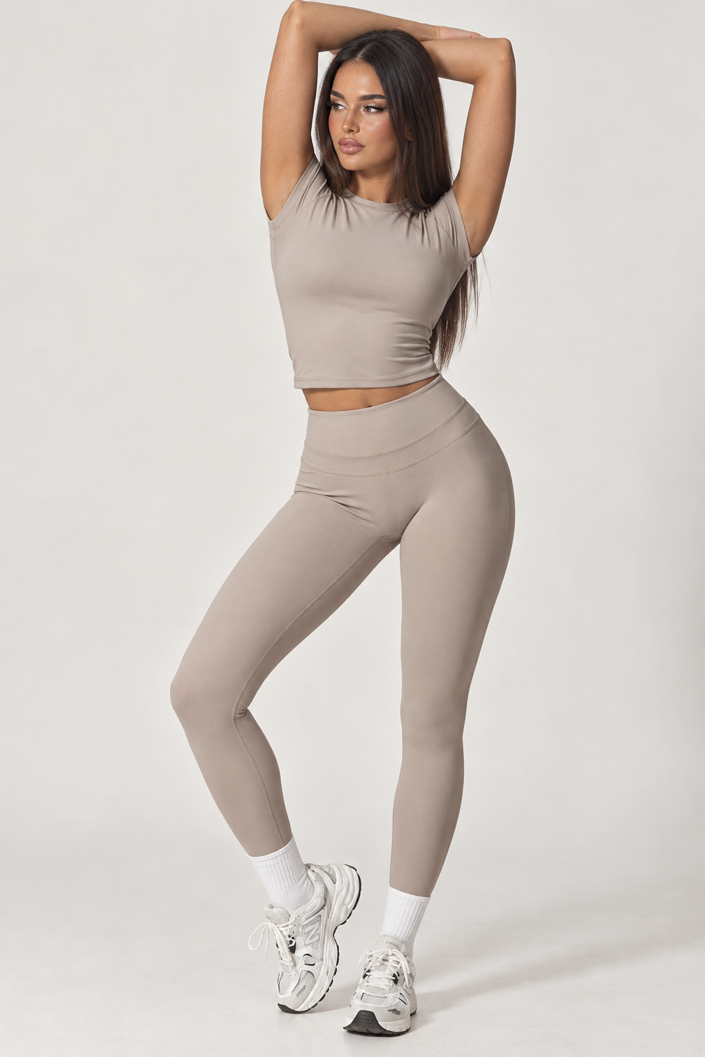 Women’s taupe gym workout set with a fitted cropped short sleeve training top and high rise full length leggings, a sleek neutral activewear outfit designed for gym sessions, strength training, exercise and everyday fitness