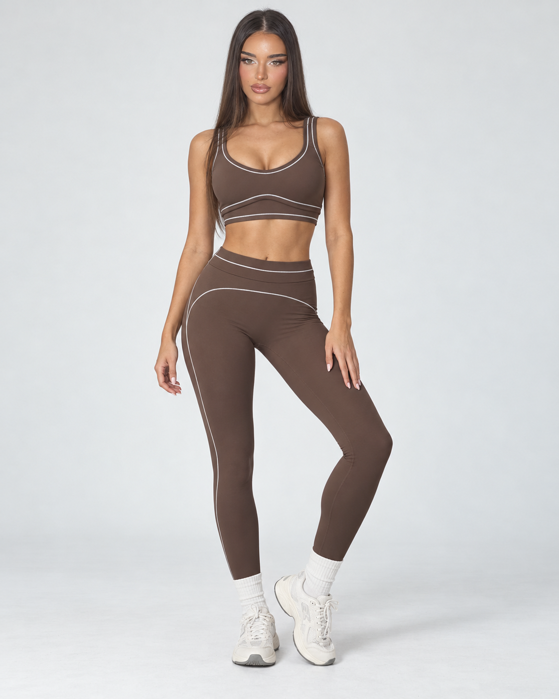 mocha women’s gym outfit with a fitted sports bra and high waisted flared activewear leggings, detailed with curved contrast seams and white piping for a body contouring workout, training and athleisure look