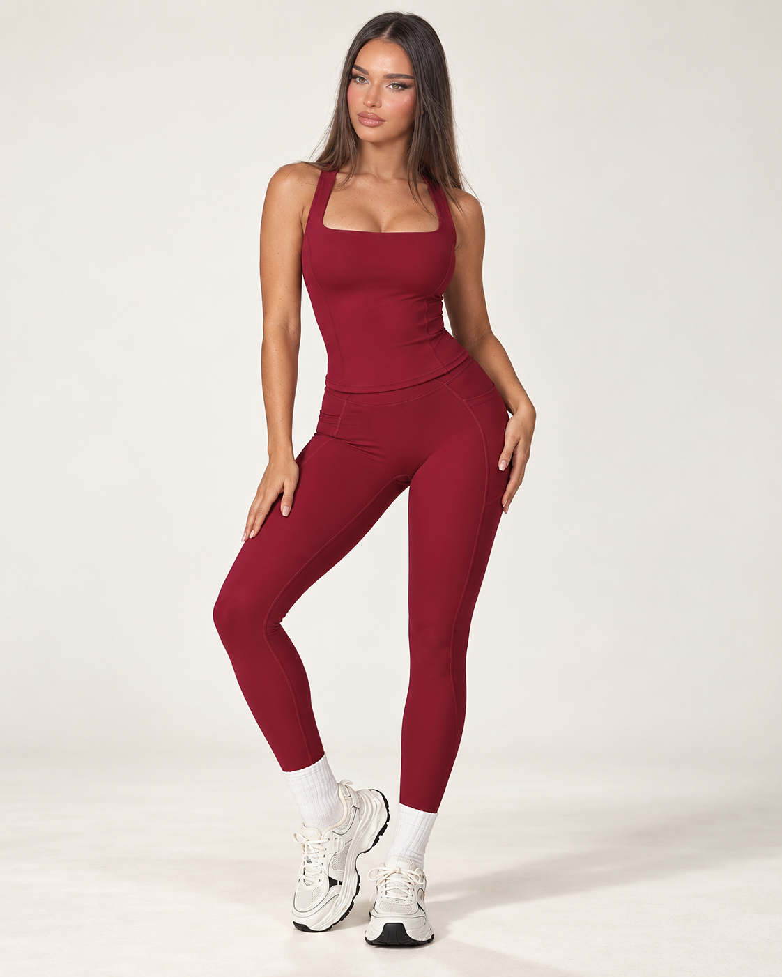 red women’s activewear co ord with a fitted sleeveless square neck training top and full length high waisted sculpting leggings with crossover V waistband, a premium ERAFITT workout and athleisure set