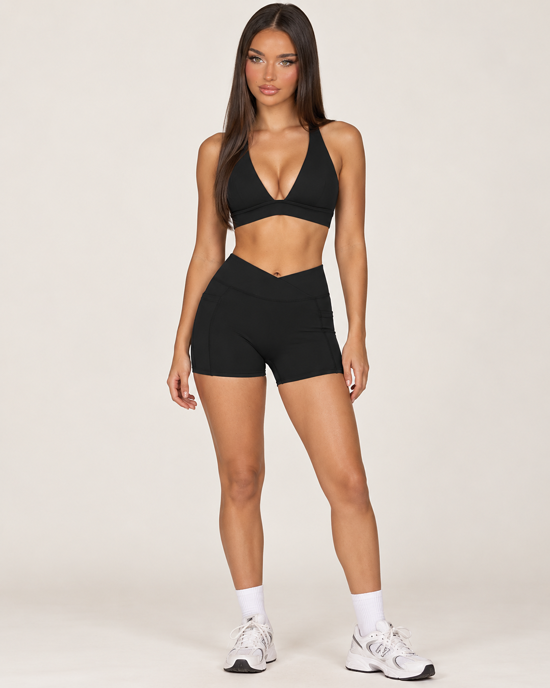 Luxury black women’s workout outfit with a fitted sleeveless square neck activewear top and high waisted body sculpting gym shorts, a coordinated neutral fitness set from ERAFITT for training and athleisure