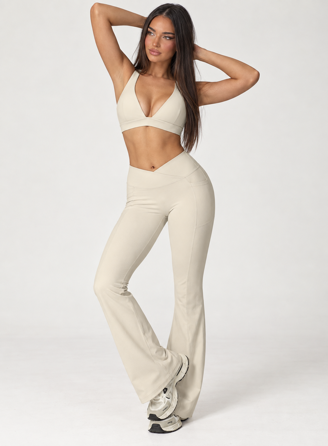 Women’s cream workout set featuring a sleeveless square neck athletic top and flattering crossover waist full length leggings, a coordinated activewear look for gym training, Pilates, exercise and athleisure