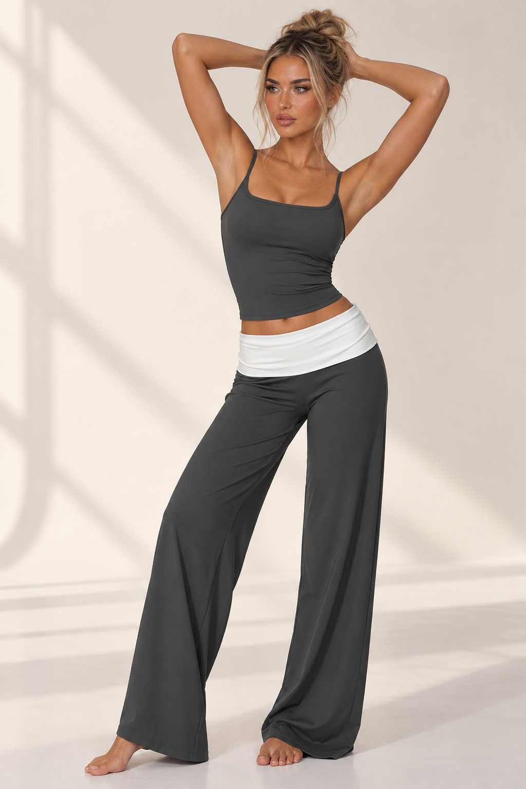 Dark ash women’s yoga outfit with a sculpted long sleeve training jacket, silver front zipper and fluid wide leg trousers