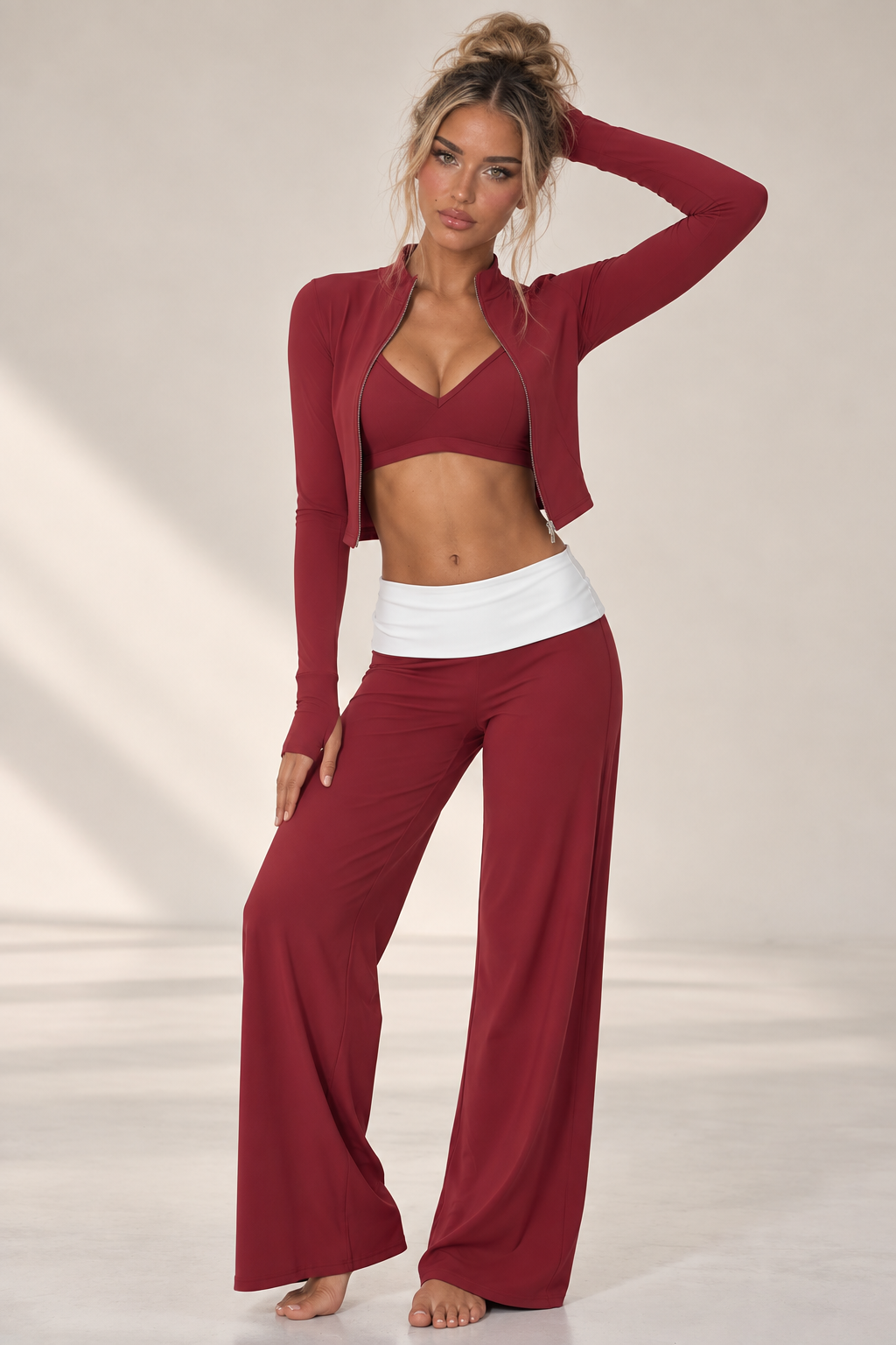 Burgundy women’s yoga outfit with thumbhole sleeves, a feminine V-front bra and relaxed high waist trousers finished with a bold white waist panel