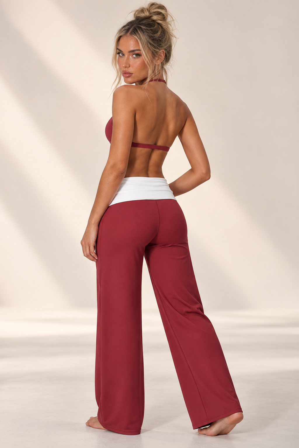 Burgundy women’s yoga outfit with thumbhole sleeves, a feminine V-front bra and relaxed high waist trousers finished with a bold white waist panel