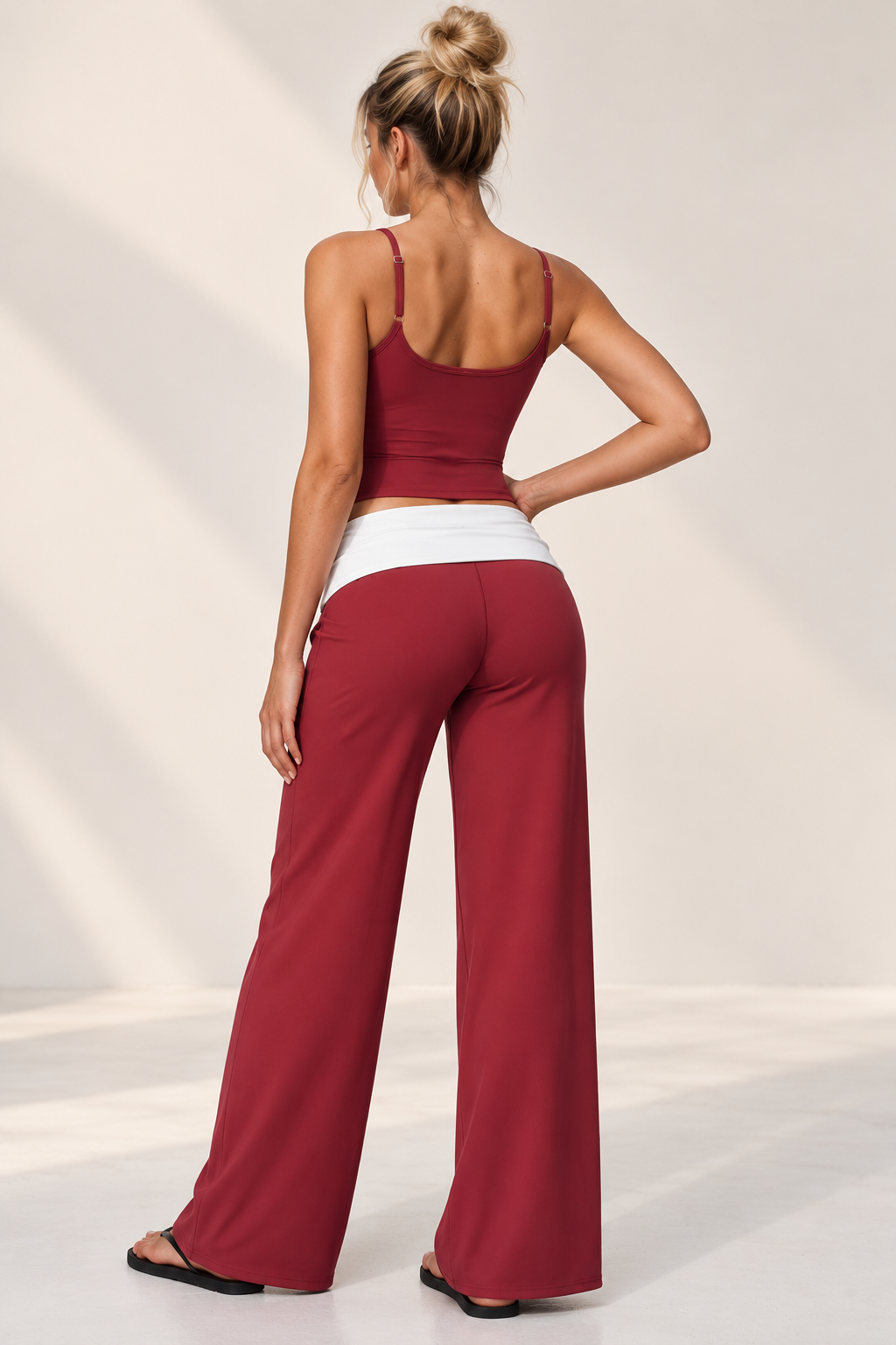 Merlot red women’s three piece Pilates set featuring a cropped zip jacket, V-neck sports bra and wide leg yoga pants with a contrasting white waistband