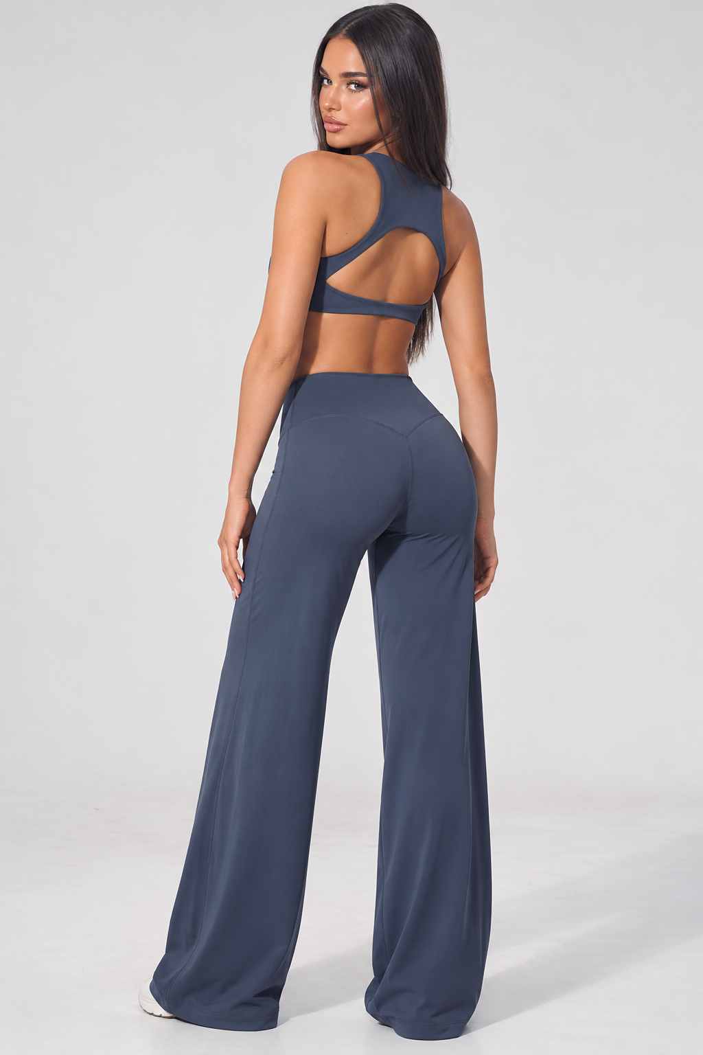 state blue women’s gym wear set featuring a cropped high neck training top and high waisted wide leg athletic pants, a feminine matching workout outfit with a streamlined waist and relaxed flowing leg silhouette
