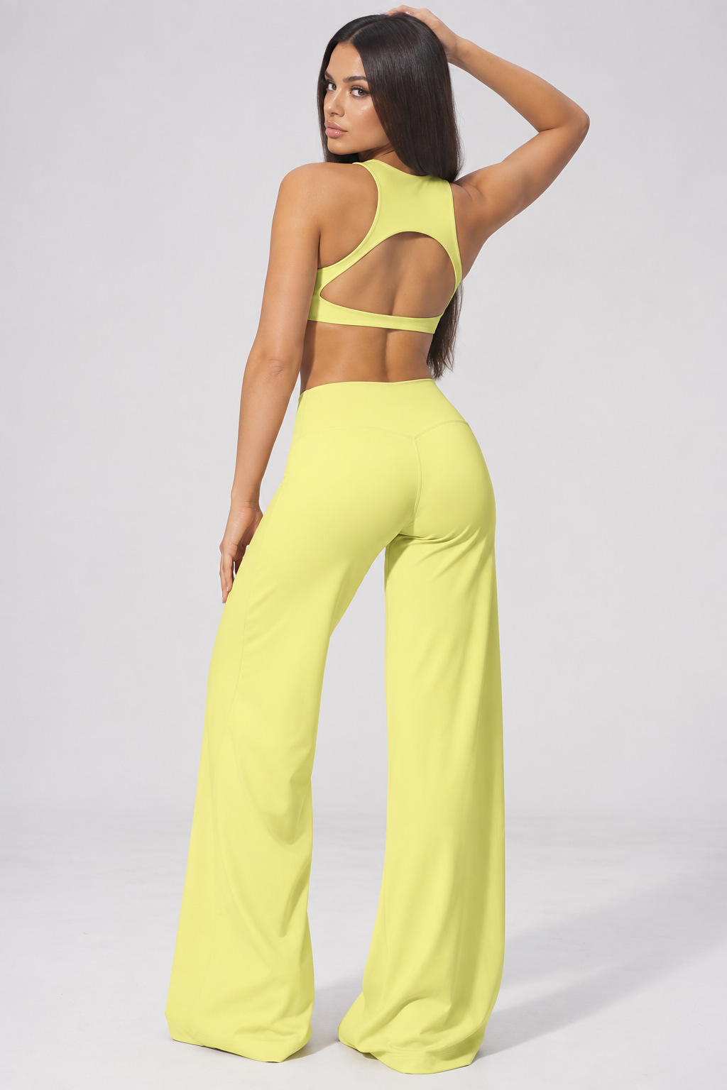 Chartreuse lime women’s activewear outfit featuring a fitted halter neck athletic top and high waisted wide leg training pants, a vibrant monochrome workout set for gym, Pilates, fitness and athleisure styling